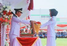 Irup Bupati Boltim Sam Sachrul Mamonto, menyerahkan pusaka bendera merah putih untuk dikibarkan, di HUT Kemerdekaan RI ke - 79, di lapangan Gogaluman Tutuyan, Kecamatan Tutuyan, Boltim, Sabtu 17 Agustus 2024. (foto.chimo/timurexpress.co)