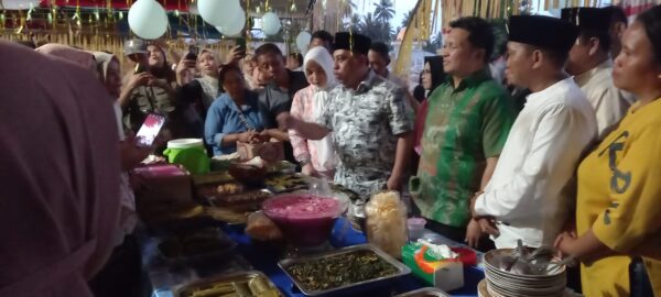 Bupati Bolmong Yusra Alhabsyi bersama rombongan, cicipi masakan warga di acara Mongalupa Desa Kinomaligan, Kecamatan Dumoga Tengah, Kabupaten Bolmong. (foto.yudi/timurexpress.co)