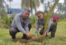Karutan Kotamobagu Aris Supriyadi (kanan) bersama Kasubsi Busen (kiri), ambil bagian penanaman ratusan Tunas kelapa di Minahasa Selatan, 5 Agustus 2025. (foto.Ist/Rutan Kotamobagu)