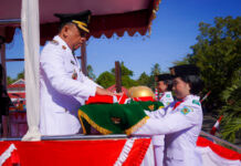 Bupati Bolmong Yusra Alhabsyi (Irup) saat menyerahkan bendera merah putih untuk dikibarkan di HUT RI ke 80, di Lapangan Upacara Kantor Bupati Bolmong, Lalow, Lolak, Kabupaten Bolmong, Minggu 17 Agustus 2025. (foto.Ist/Diskominfo Bolmong)