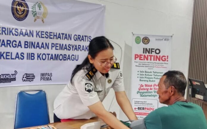Tampak salah satu petugas kesehatan Poliklinik Rutan Kotamobagu saat memberikan pelayanan kesehatan gratis kepada salah satu pengunjung di Aula PTSP Rutan, Senin 16 Maret 2026. (foto.Ist/Rutan Kotamobagu)