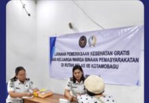 Tampak dua petugas Poliklinik Rutan Kotamobagu saat memberikan layanan kesehatan gratis ke salah satu keluarga warga binaan, di ruang PTSP Rutan, Kamis 26 Februari 2026. (foto.Ilham/Rutan Kotamobagu)