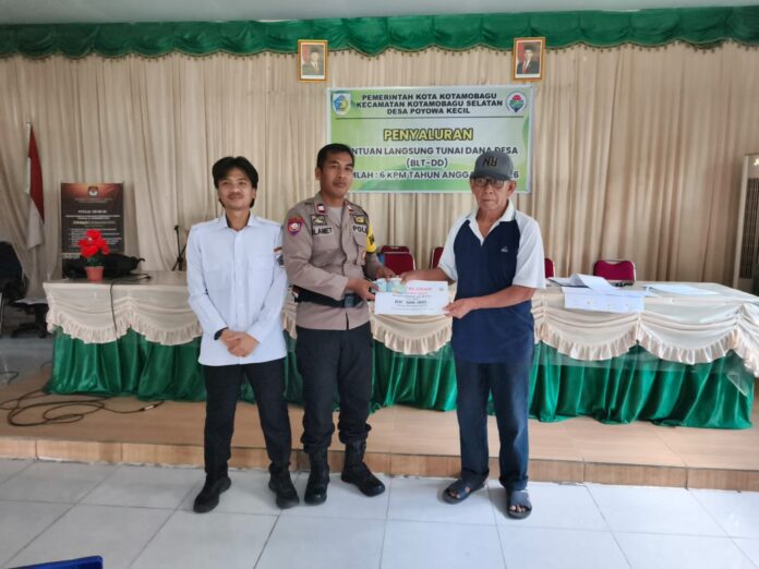 Tampak Bhabinkamtibmas(tengah), ikut ambil bagian pada kegiatan penyaluran BLT DD yang berlangsung, di Balai Desa Poyowa Kecil. (foto.dok/Pemdes Poyowa Kecil)